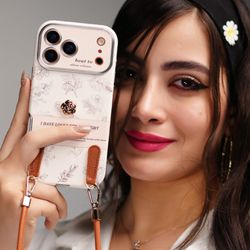 قاب موبایل آیفون گل طلایی انگلیسی الگانس محافظ لنزدار + بندست چرمی